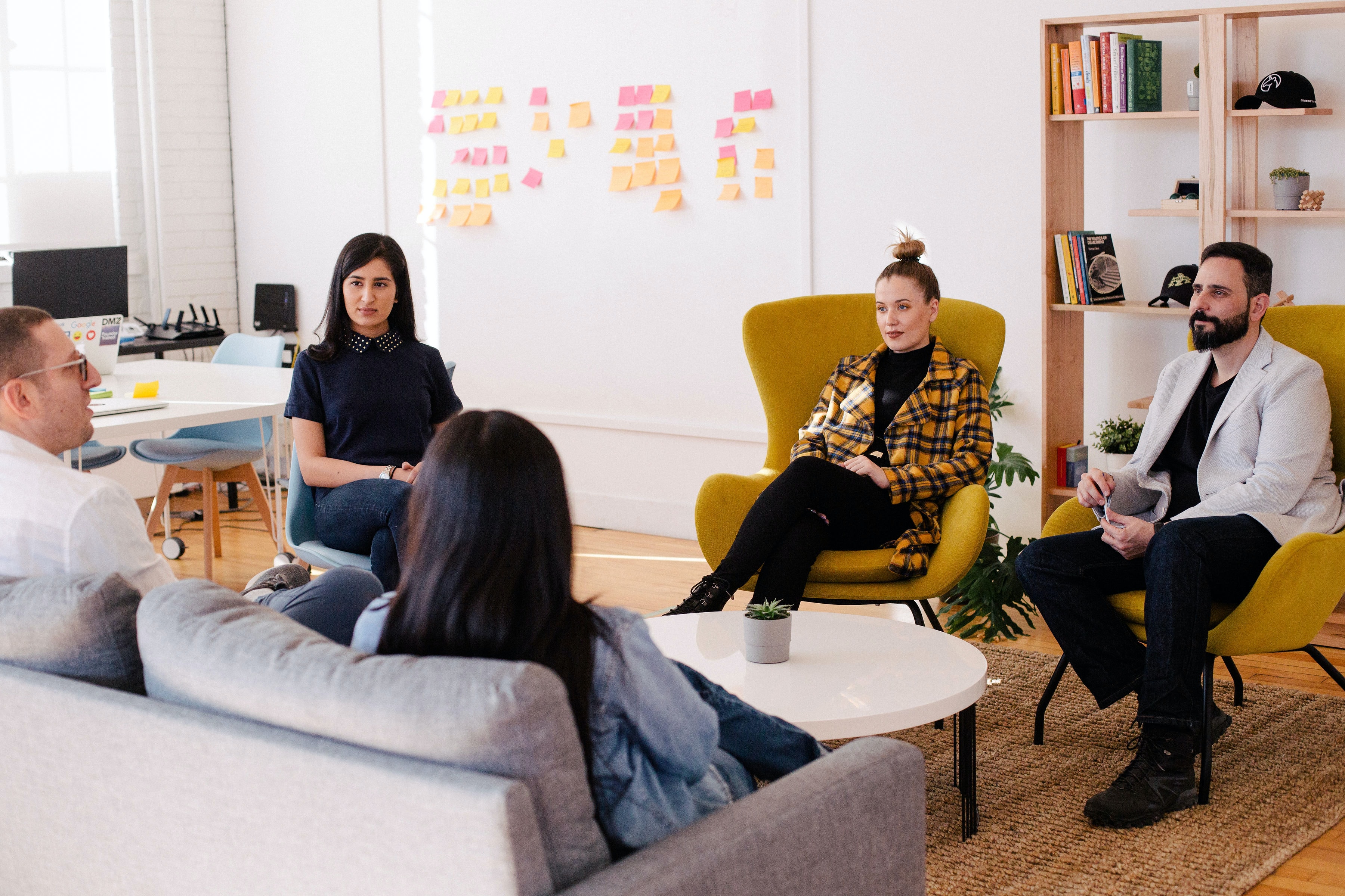 people sitting in a circle on couches and chairs